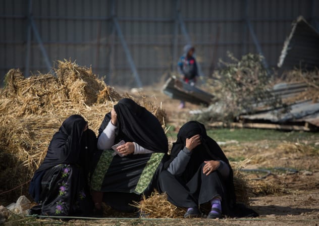 Bedouin women sit outside their demolished homes in the Bedouin village of Umm al-Hiran in the Negev desert, in the in the Southern Israel, January 18, 2017. 