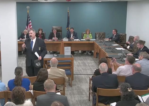 New Hampshire GOP state Rep. Travis Corcoran (center) walks out of his own disciplinary hearing for tweeting a "final solution" reference at a Jewish colleague, April 27, 2026.