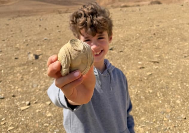 Eight-year-old Dor Wolynitz with the over 1,700-year-old statuette fragment he found in the Ramon Crater area, May 11, 2026.