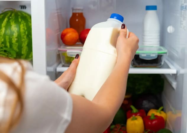 A woman taking milk out of the fridge 