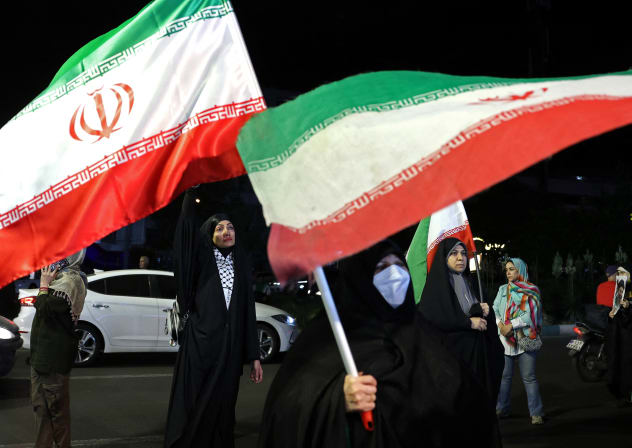 Women hold Iran's national flags during an anti-US and Israel protest at the Hafte Tir Square in Tehran on May 17, 2026.