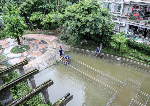 CHINA-WEATHER Rescuers use pumps to drain off water after heavy rains at a flooded residential compound in southwestern China's Chongqing municipality on July 9, 2025.