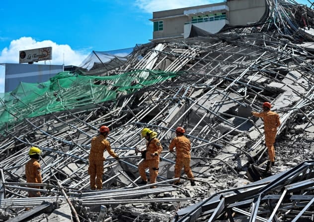 Rescue workers search for survivors among debris as a nine-storey building under construction collapsed in Balibago, Angeles City, Pampanga, Philippines, May 24, 2026.