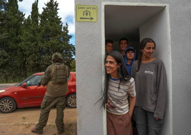 Israeli soldiers take position as civilians take cover during a Hezbollah attack near the Israeli border with Lebanon in northern Israel, May 19, 2026. 