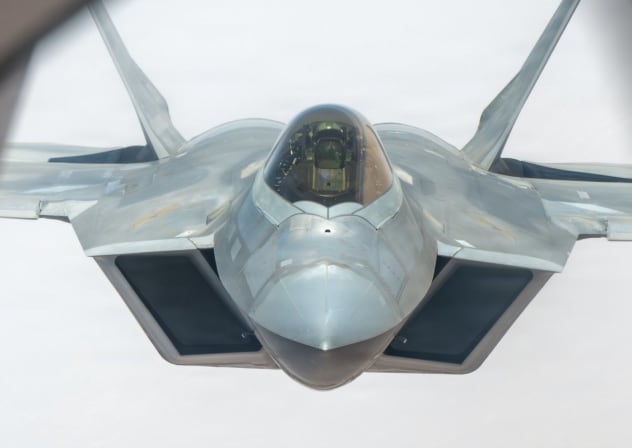 A US Air Force F-22 Raptor stealth fighter is refueled by a KC-135 Statotanker while flying over the Middle East.