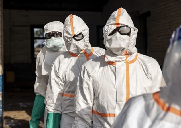 Workers line up to disinfect their protective equipment at General Referral Hospital of Mongbwalu during the Ebola outbreak response in Mongbwalu, Ituri province, eastern Democratic Republic of Congo, on May 20, 2026.