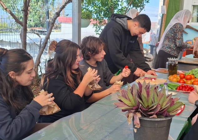 Jewish and Druze students come together and share bread and vegetables grown at a farm extension of the Amal high school in Yanuh Jat in November 2025.