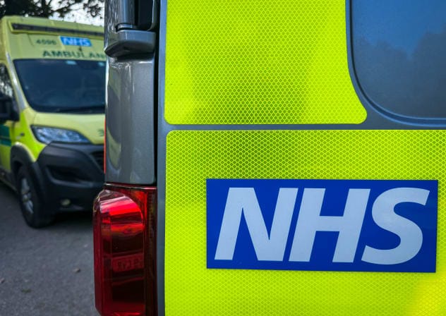 The NHS logo is displayed on a ambulance parked close to a nearby hospital, on October 20, 2025.