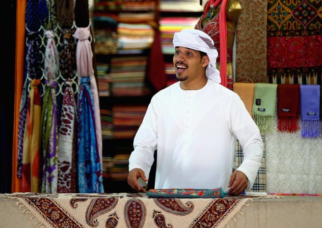 A vendor organises textiles at a shop in Central Souq on July 22, 2015 in Sharjah, United Arab Emirates.