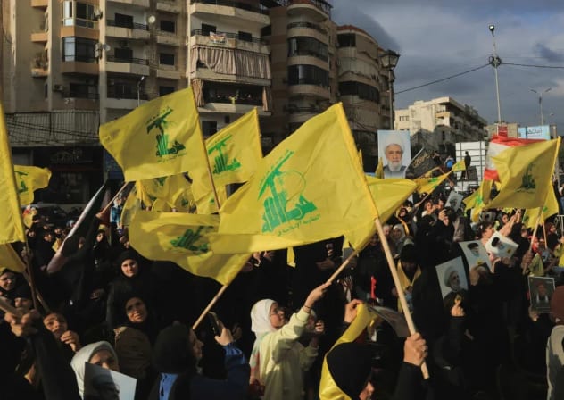 Varias personas sostienen banderas de Hezbolá mientras conmemoran la retirada de Israel del sur del Líbano en 2000, en los barrios del sur de Beirut, Líbano, el 25 de mayo de 2026. 