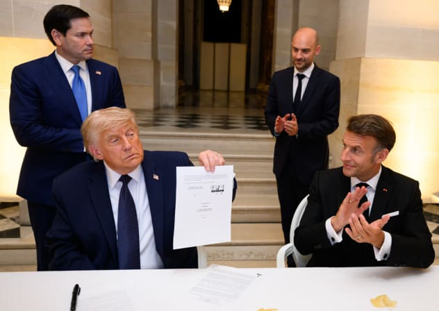 US President Donald Trump holds up the memorandum of understanding, signed by the US, and Iran, at the Palace of Versailles, in France. 