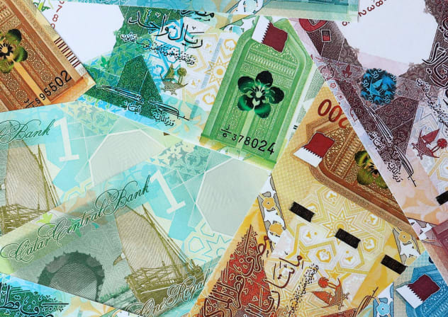Qatari riyal money bills in pile. Big amount of Qatar QAR currency cash close up. 
