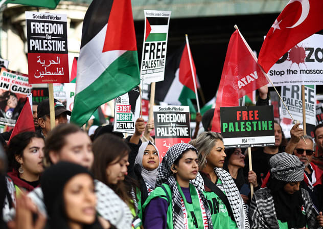 PEOPLE HOLD up placards and Palestinian flags as they gather to take part in a 'March For Palestine' in London on October 28, 2023, to call for a ceasefire in the conflict between Israel and Hamas. 