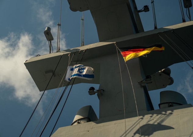 Israeli and German flags fly from a naval vessel during a German delegation's visit to Haifa Naval Base, published June 25, 2026.