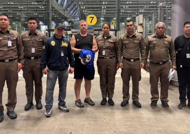 Police officers pose with Carman Simon Peter, an Australian man arrested in the suspected murder of a 17-year-old Thai girl in Pattaya, at Suvarnabhumi International Airport, in Samut Prakan, Thailand June 27, 2026.