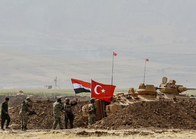  TURKEY-IRAQ-KURDS-MILITARY-DRILL A photographer takes pictures as soldiers stand next to tanks bearing Turkish and Iraqi flags during a joint military exercise near the Turkish-Iraqi border at Silopi district in Sirnak on September 26, 2017.