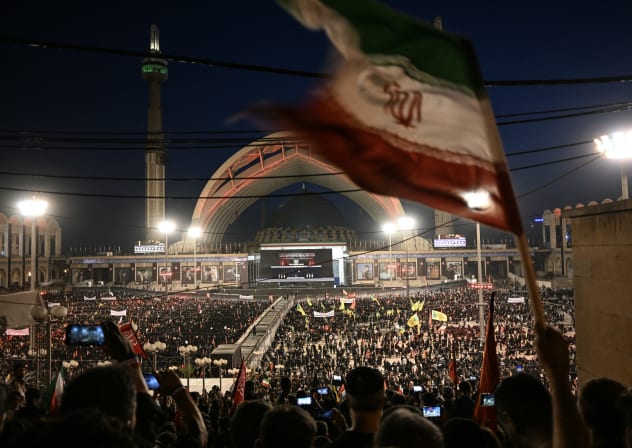 Mourners wave a national flag as the gather to pay tribute to Iran's slain supreme leader Ayatollah Ali Khamenei at the Grand Mosalla on the second day of funeral ceremonies in Tehran on July 5, 2026. 