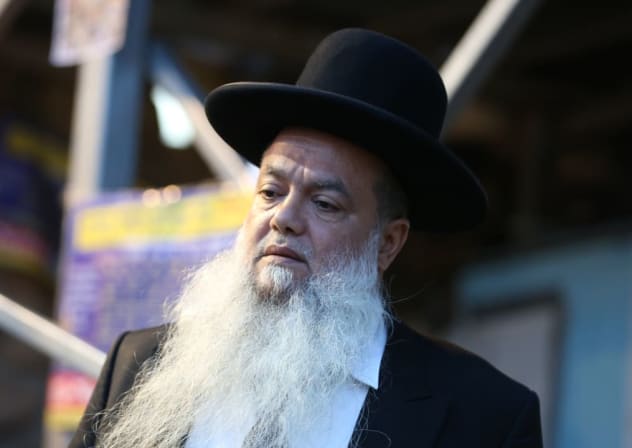 El rabino Yigal Cohen enciende velas en memoria de las 45 víctimas que perdieron la vida en una estampida, en el lugar donde se produjo la tragedia, en el monte Merón, la semana pasada. 6 de mayo de 2021. 