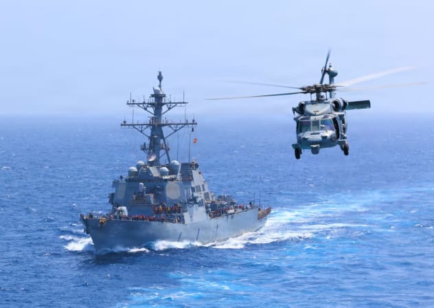 USS Donald Cook (DDG 75) transits the Arabian Sea while an MH-60S Sea Hawk flies nearby.