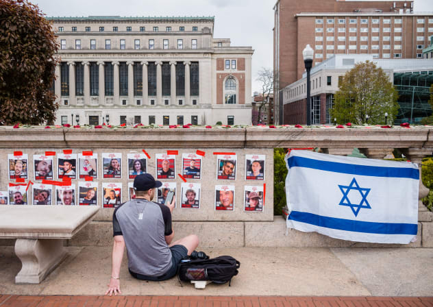 A Jewish student sits in front of posters of October 7 hostages at Columbia University. 