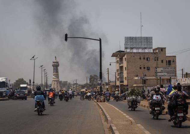 A column of black smoke rises above buildings as traffic passes the Africa Tower monument in Bamako on April 26, 2026; Illustrative.