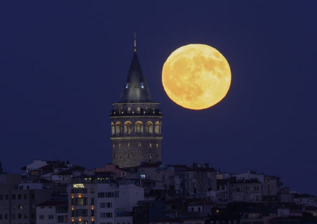 A full moon rises behind the Galata Tower in Istanbul, Turkey, July 29, 2026.
