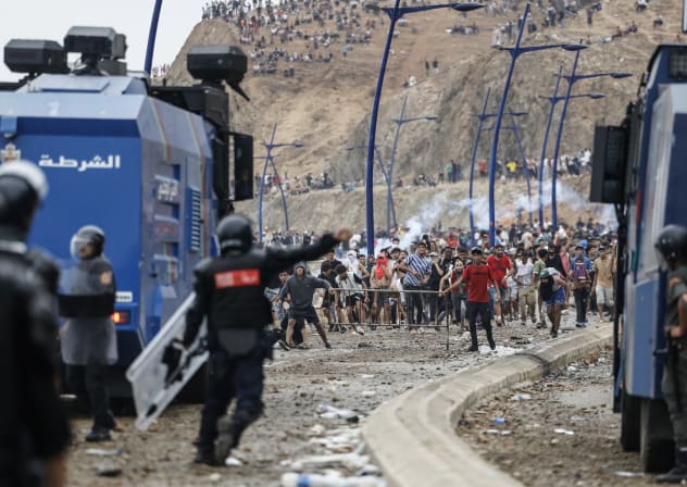 Moroccan security forces clash with migrants attempting to cross into Spain's North African enclave of Ceuta near the town of Fnideq, on the Morocco-Spain border, on July 31, 2026. 