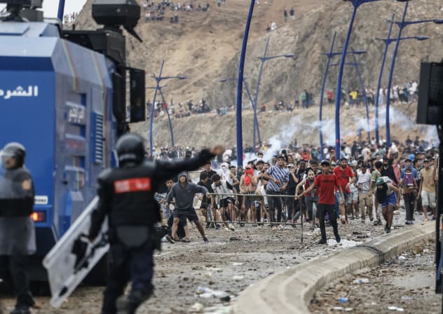 Moroccan security forces clash with migrants attempting to cross into Spain's North African enclave of Ceuta near the town of Fnideq, on the Morocco-Spain border, on July 31, 2026. 