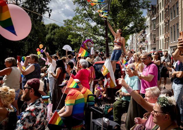 Participants and spectators cheer during the Canal Parade in Amsterdam on August 1, 2026; illustrative.
