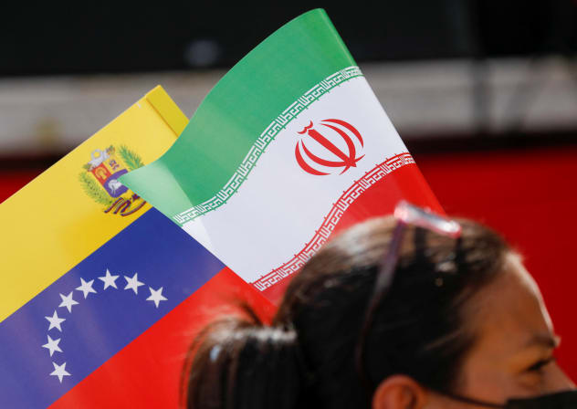 A Venezuelan government supporter holds the flags of Iran and Venezuela while participating in a march in support of Iran, amid the ongoing conflict between Israel and Iran, in Caracas, Venezuela, June 19, 2025.