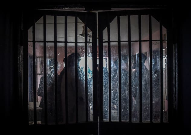 Taliban members are seen from a window as they inspect inside a prison cell at Pul-e-Charkhi prison, located on the outskirts of Kabul on October 17, 2021.
