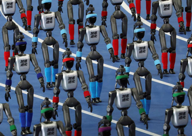 Booster Robotics humanoid robots walk in formation during the opening ceremony for the second World Humanoid Robot Games at the National Speed Skating Oval in Beijing, China August 22, 2026.