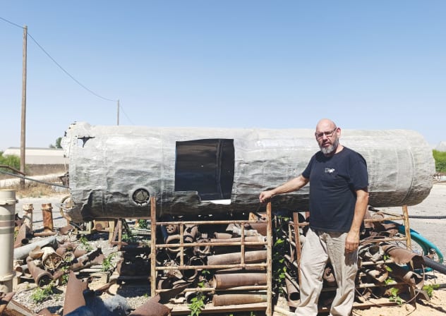 YARON BOB stands next to a remnant of an Iranian ballistic missile in the backyard of his blacksmith studio in Yated. 