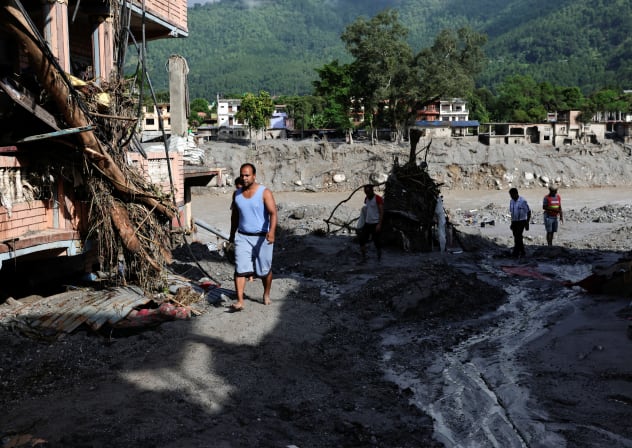 People move through a mud covered road following flash floods and a mudslide in Trishuli, Nuwakot district, Nepal, August 28, 2026.