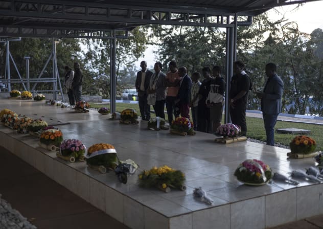 People pray by a mass grave at Nyanza Genocide Memorial Center in Kigali, Rwanda on April 11, 2024.