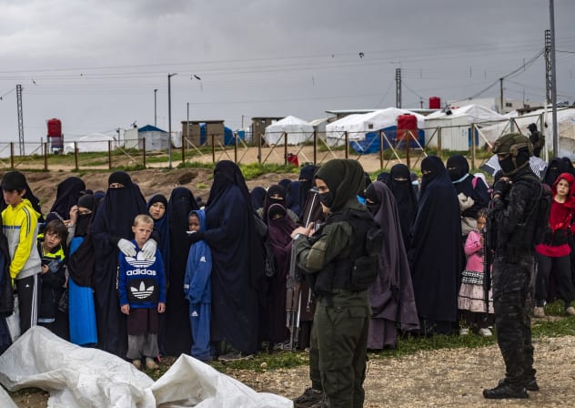 Women and children queue during a joint security operation by Syria's Kurdish Internal Security Police Force, also known as Asayesh, and the Kurdish-led Syrian Democratic Forces (SDF) at Camp Roj where foreign relatives of people suspected of belonging to the Islamic State (IS) group are held.
