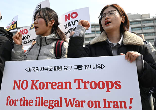 South Korean protesters hold placards during a protest against Trump's request to dispatch warships to the Strait of Hormuz in front of the US embassy in Seoul on March 16, 2026. 