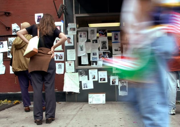 New Yorkers look at posters of missing persons days after the World Trade Center attack in New York on Sept. 11, 2001.