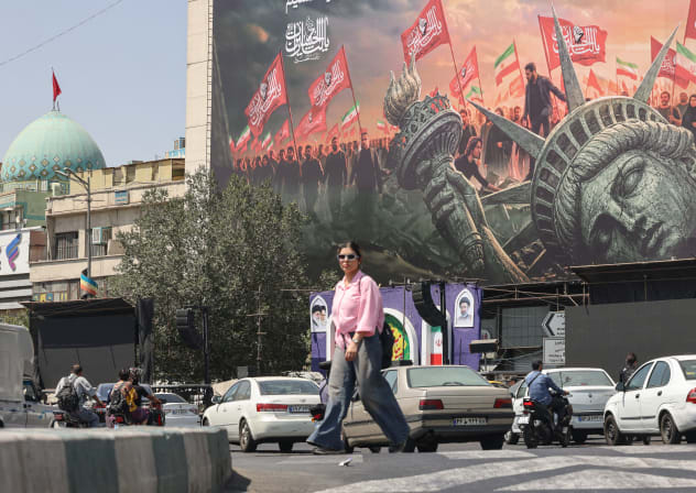 People walk past an anti-US billboard at Enghelab Square in central Tehran on September 2, 2026.