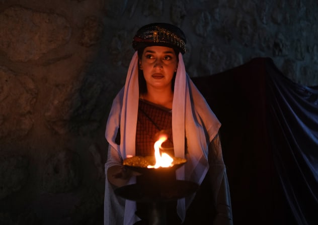 A Yazidi woman holds a candle during a ceremony marking Charshama Sor, or Red Wednesday, the Yazidi New Year, at Lalish temple in Shaikhan near Dohuk in northern Iraq on April 14, 2026. Northern Iraq's Kurdistan Region is home to the Yazidi religious minority.