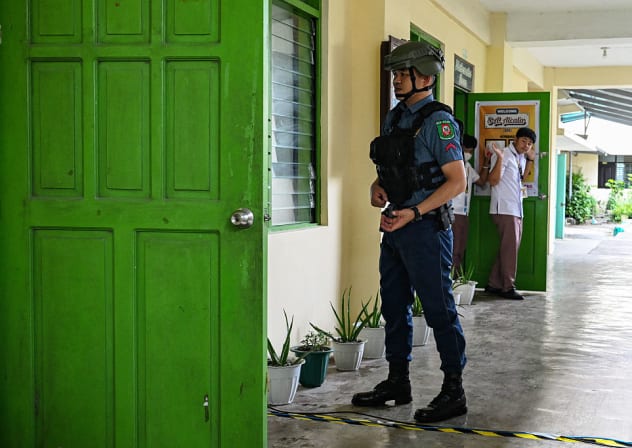 A policeman instructs students to evacuate during a nationwide school drills to safeguard students from armed intruders, at a school in San Rafael, Bulacan on September 3, 2026. 