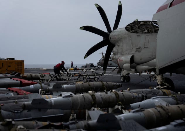 A sailor handles munitions on the flight deck of the USS George Washington in the Arabian Sea, September 13, 2026. The aircraft carrier is enforcing a US naval blockade against Iran and providing cover for commercial vessels transiting the Strait of Hormuz.