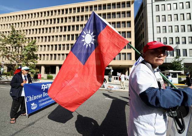 A demonstrator holds a Taiwanese flag during a protest near the White House, on the day of a meeting between Chinese President Xi Jinping and US President Donald Trump in Washington, DC, US, September 24, 2026. 