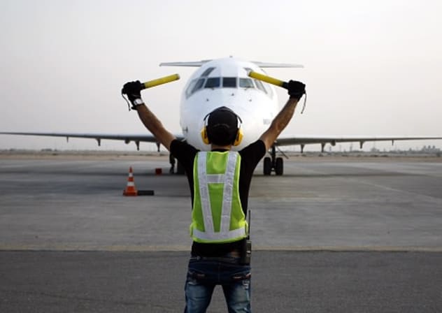 A ground controller directs an airliner on the apron on August 29, 2015 at the international airport of the city of Najaf as Iraqis are heading to Saudi Arabia to perform the annual Muslim Hajj pilgrimage in the holy city of Mecca. 