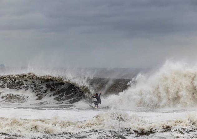 A surfer catches a wave as a nor'easter batters the US northeast coast, in Rockaway, New Jersey, US, September 26, 2026.
