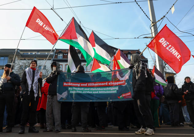 Protesters hold Palestinian flags, flags with the logo of Germany's Die Linke (The Left) party, and a banner during a pro-Palestinian demonstration, in Leipzig, Germany January 17, 2026. The banner reads: 'Stop the occupation and genocide! For freedom and equality between the Jordan and the Mediterr
