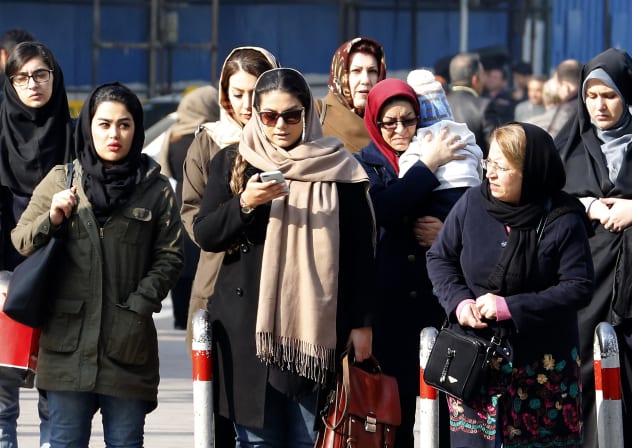 Iranian women wearing hijab walk down a street in the capital Tehran on February 7, 2018.