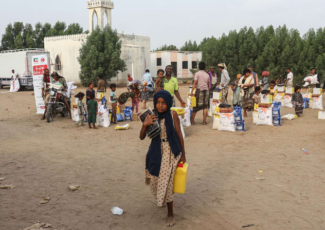 A girl carries a jerrycan as displaced people living in temporary shelters receive food aid in Al-Khawkhah, in Yemen's western Hodeidah province, on July 30, 2026.