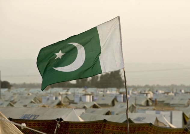 A Pakistani flag flutters in the wind.