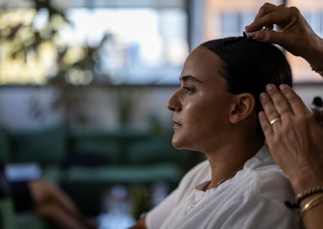 British-Israeli Emily Damari, 30, a former hostage, has her hair done during a photo shoot for her clothing brand which carries the slogan ‘never lose yourself.’